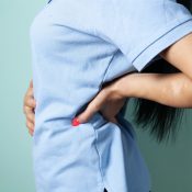 Woman holding her stomach showing digestive discomfort related to SIBO symptoms and gut health concerns