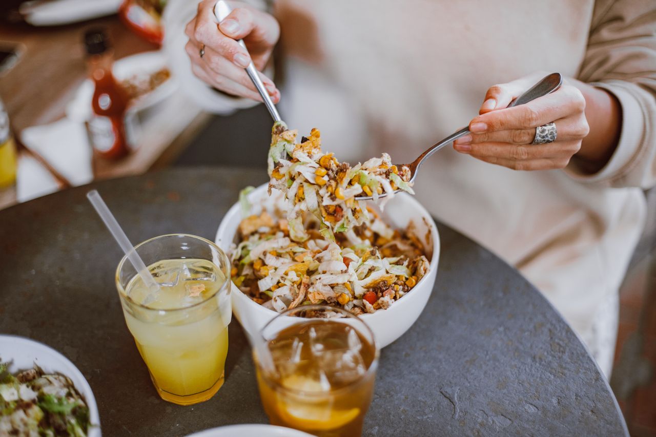 Woman eating a healthy salad to support digestion and gut health