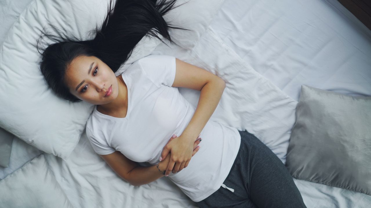 Woman experiencing stomach bloating and digestive discomfort after eating